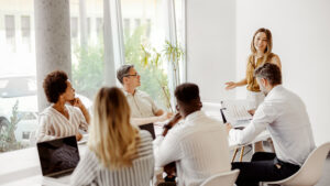 Group of associates sitting around a large table having a meeting.