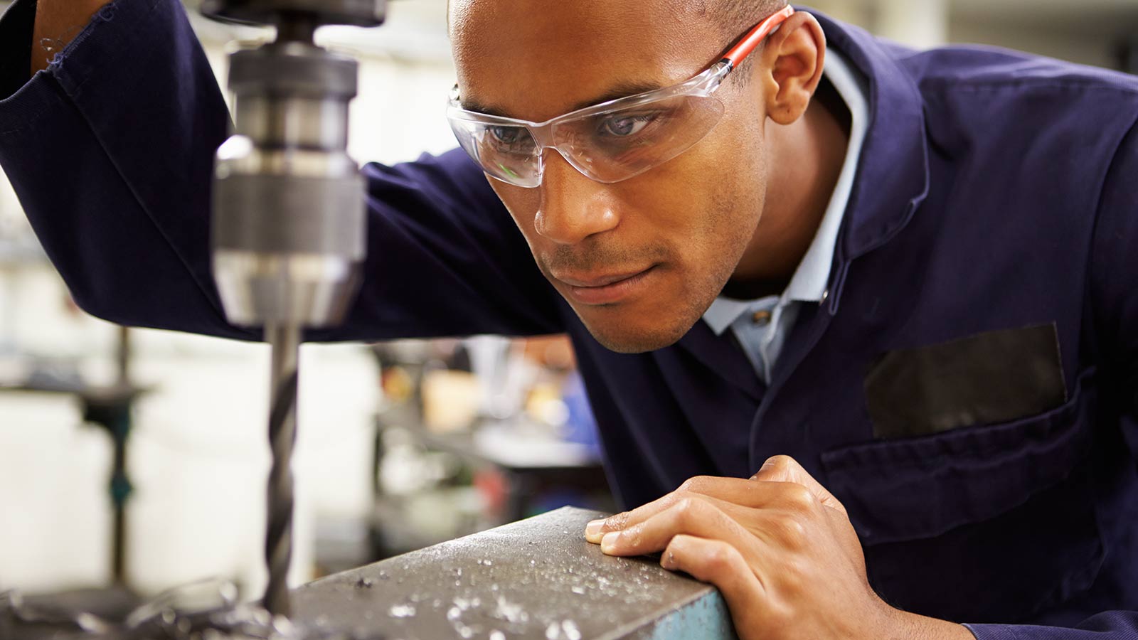 Man wearing safety goggles while drilling.