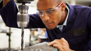 Man wearing safety goggles while drilling.