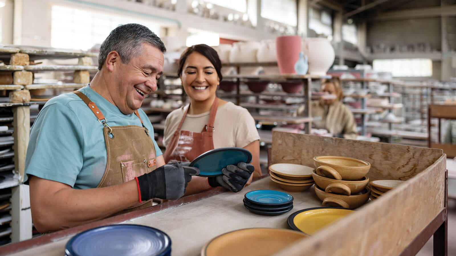 A father and daughter work together in their ceramic business knowing they’re providing the benefits of PEPs to the employees in their small business.