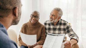 Senior couple talking to their agent about dental plans.