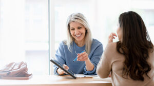 lady helping client at a table talking about finances.