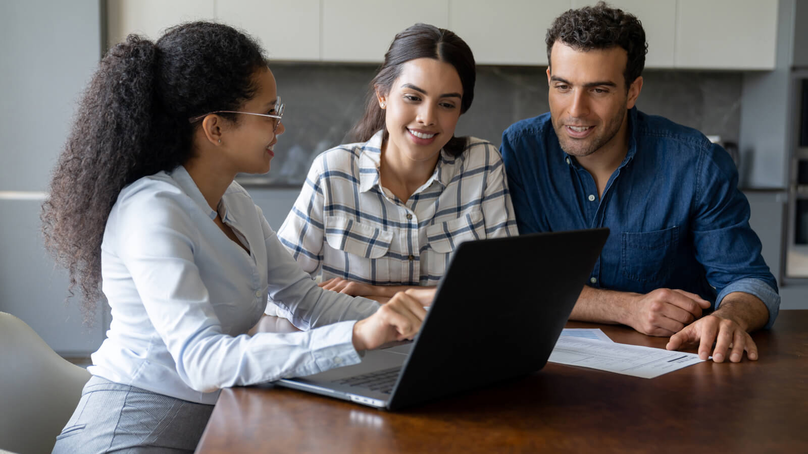 A financial professional meets with her clients, a husband and wife in their late 30s, for their annual financial review and discuss their financial goals.