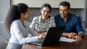 A financial professional meets with her clients, a husband and wife in their late 30s, for their annual financial review and discuss their financial goals.