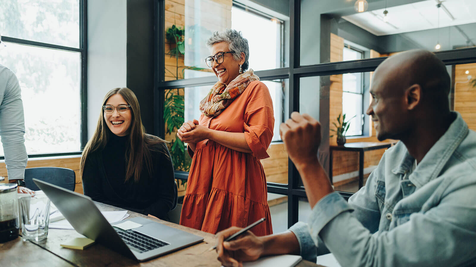 The CEO of a small company enjoys a laugh with some of her employees during a meeting to talk about employee engagement.