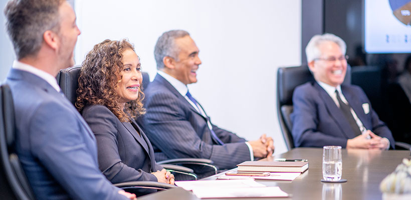 Board members sitting around a table in a meeting room.