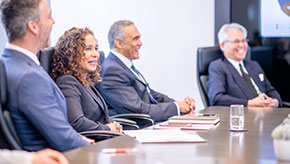 Board members sitting around a table in a meeting room.